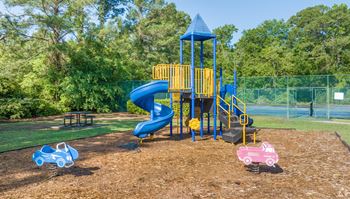 A playground with a blue slide and a yellow structure at The Preserve at Pine Valley Apartments, Wilmington, NC